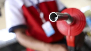 Frentista segura mangueira de combustível