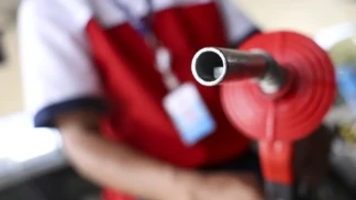 Frentista segura mangueira de combustível