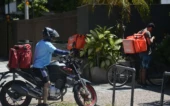 Entregadores de aplicativos estão na porta de domicílios.