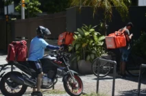 Entregadores de aplicativos estão na porta de domicílios.