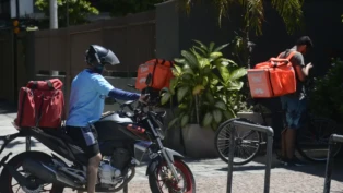 Entregadores de aplicativos estão na porta de domicílios.