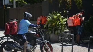 Entregadores de aplicativos estão na porta de domicílios.