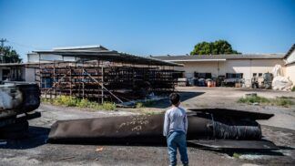 Um menino observa os destroços de um míssil iraniano que caiu em um kibutz, após o Irã lançar ataques com mísseis em resposta aos ataques dos EUA e de Israel.