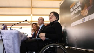 Maria da Penha está numa cadeira de rodas durante evento