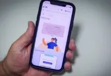 Uma mão segura um celular, cuja tela mostra o site do Prouni
