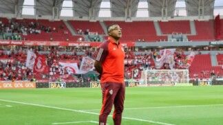 Técnico Roger Machado acompanha a partida em pé no banco de reservas