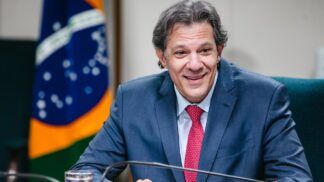 Fernando Haddad sorri durante audiência no Ministério da Fazenda