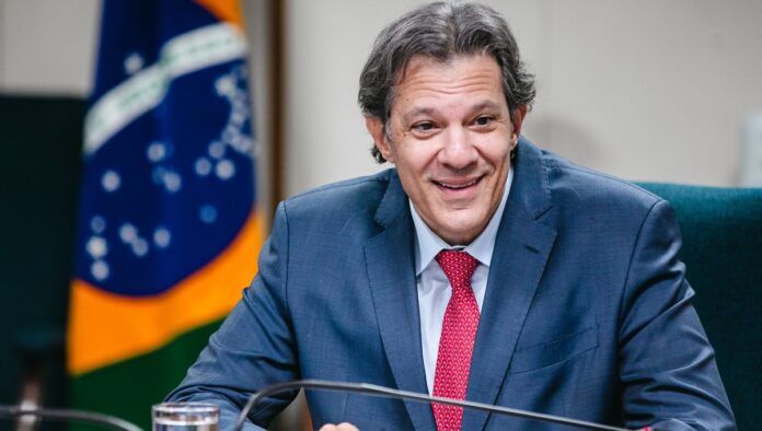 Fernando Haddad sorri durante audiência no Ministério da Fazenda
