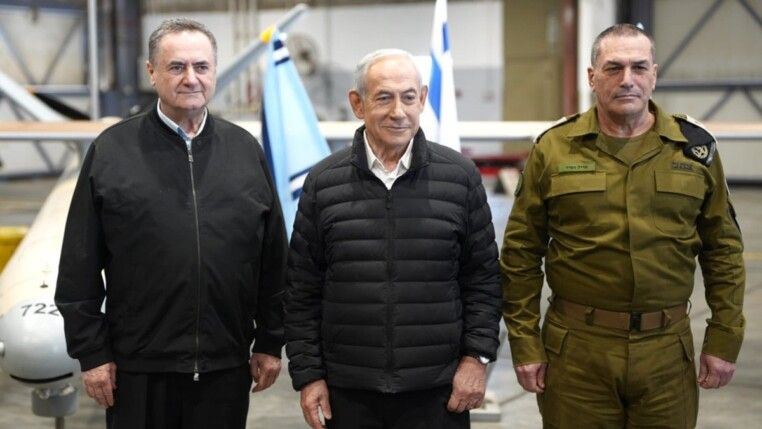 O primeiro-ministro de Israel, Benjamin Netanyahu, ao lado do ministro da Defesa de Israel, Israel Katz, e um oficial militar em uma base aérea