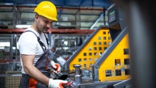 Retrato de operário trabalhando em máquina industrial em planta de produção