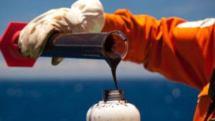 Funcionário da Petrobras deposita petróleo num recipiente