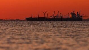 Silhueta de um navio-tanque de petróleo e produtos químicos no Golfo de Fos-sur-Mer, ao pôr do sol, em Martigues, França