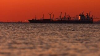 Silhueta de um navio-tanque de petróleo e produtos químicos no Golfo de Fos-sur-Mer, ao pôr do sol, em Martigues, França