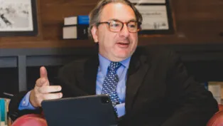 Roberto Podval está sentado e gesticula enquanto fala