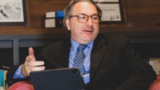 Roberto Podval está sentado e gesticula enquanto fala