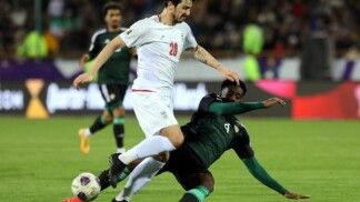 O iraniano Sardar Azmoun (número 20) em ação com o jogador dos Emirados Árabes Unidos Kouame Kouadio