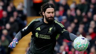 Alisson pega a bola de futebol com a mão direita