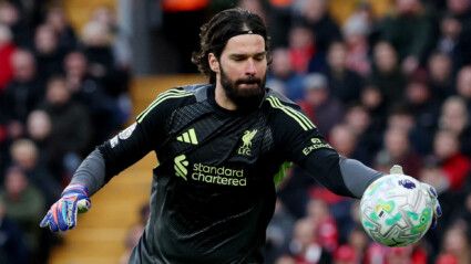 Alisson pega a bola de futebol com a mão direita