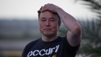 Elon Musk passa a mão esquerda no cabelo olhando para a frente
