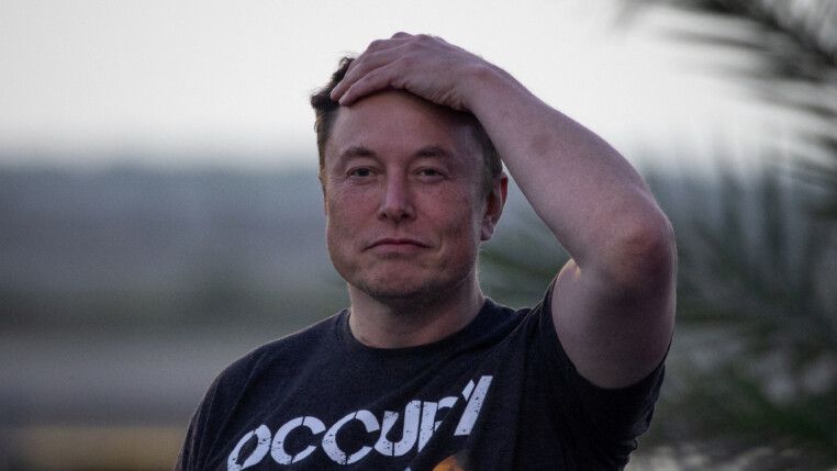 Elon Musk passa a mão esquerda no cabelo olhando para a frente