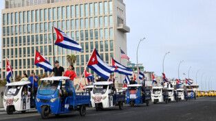Cubanos fazem manifestação contra EUA diante da embaixada do país, em Havana.