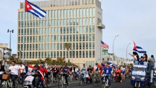 Cubanos fazem manifestação contra EUA diante da embaixada do país.