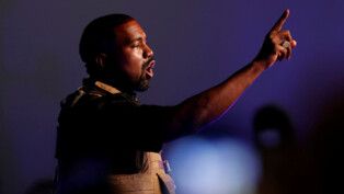 Kanye West levanta o dedo indicado em direção ao público durante comício político