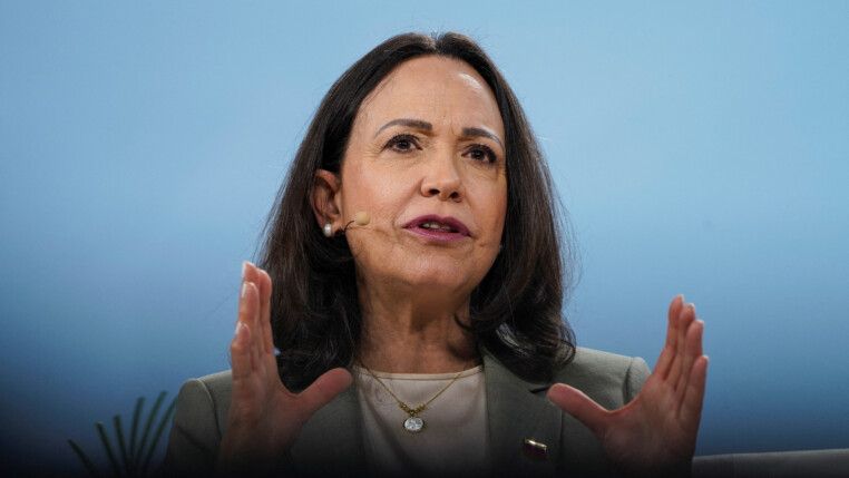 María Corina gesticula enquanto fala ao microfone