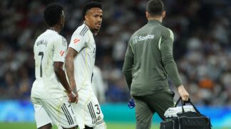 Militão anda no gramado na companhia do médico do Real Madrid