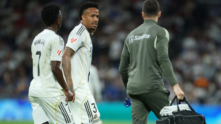 Militão anda no gramado na companhia do médico do Real Madrid