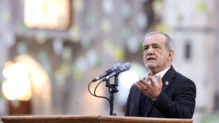 Presidente do Irã gesticula enquanto discursa ao microfone