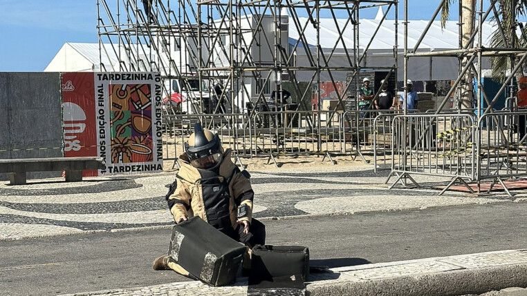 Homem do esquadrão antibomba atua perto da montagem do palco