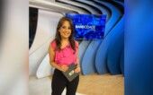 Alice Ribeiro está no estúdio à frente do logo da Band