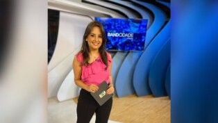 Alice Ribeiro está no estúdio à frente do logo da Band