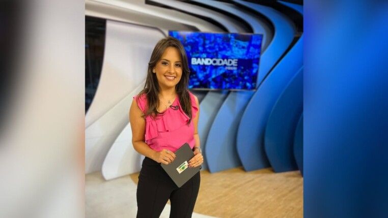 Alice Ribeiro está no estúdio à frente do logo da Band