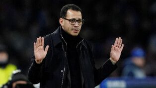 Técnico veste preto e faz sinal com as duas mãos durante jogo