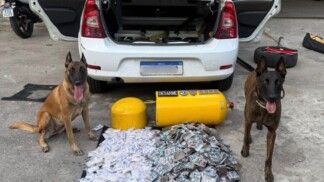 Dois carros estão ao lado de drogas apreendidas e do cilindro de gás vazio, à frente de um carro