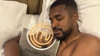 Homem abraçado com prêmio dourado.