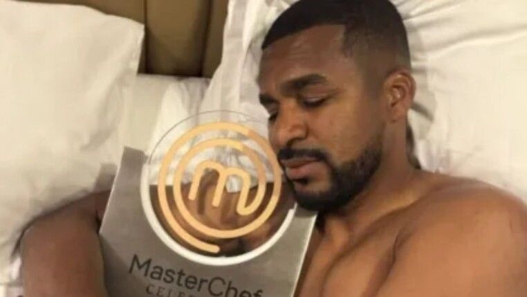 Homem abraçado com prêmio dourado.