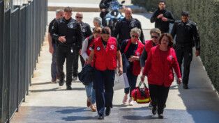 Equipes de resgate e policiais caminham em frente ao Tribunal de Apelação de Atenas após o ataque.