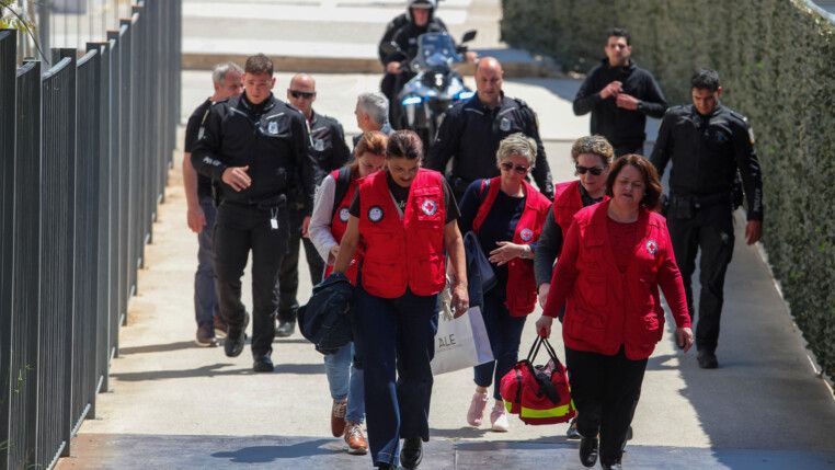 Equipes de resgate e policiais caminham em frente ao Tribunal de Apelação de Atenas após o ataque.