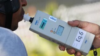 Homem sopra no bafômetro durante blitz