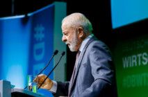 De perfil, Lula fala ao microfone durante evento