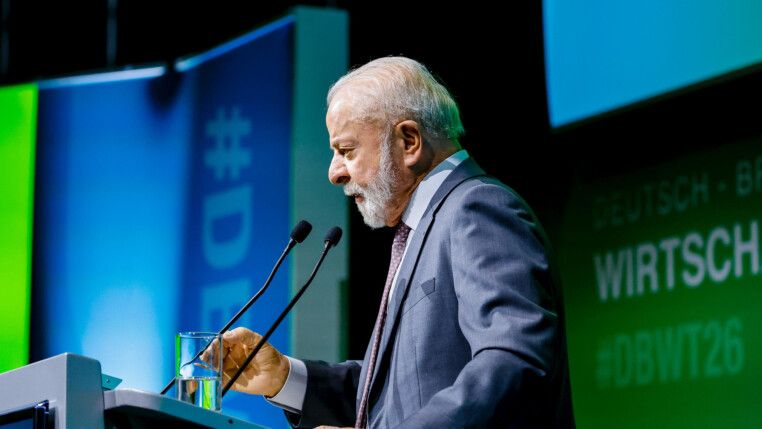 De perfil, Lula fala ao microfone durante evento