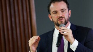 Durigan gesticula e fala ao microfone