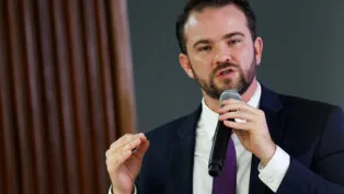 Durigan gesticula e fala ao microfone