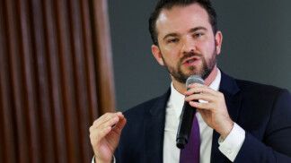 Durigan gesticula e fala ao microfone