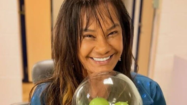 Mulher com franja dando um sorriso para a câmera.