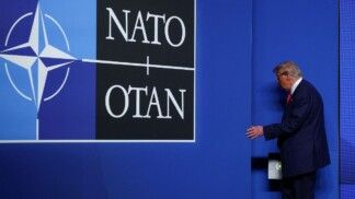 Donald Trump atravessa porta com o logo da Otan ao lado