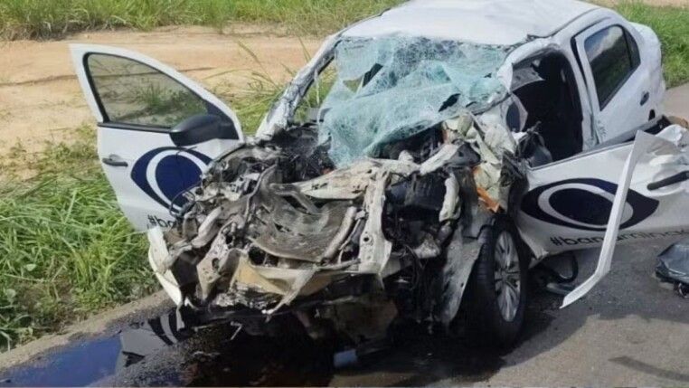 Carro branco, com o logo da Band nas portas, amassado após o acidente